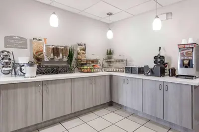 a restaurant with a counter with food on it at Microtel Inn & Suites Modesto in Ceres