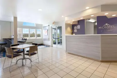 a lobby with a counter and a table and chairs at Microtel Inn & Suites Modesto in Ceres