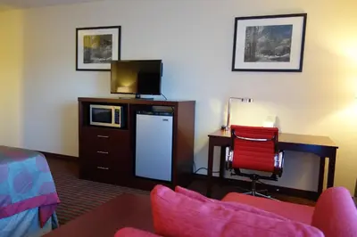 a hotel room with a tv and a desk with a chair at Ramada by Wyndham Sacramento in Sacramento