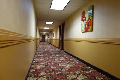 an empty hallway with a tile floor in a building at Ramada by Wyndham Sacramento in Sacramento