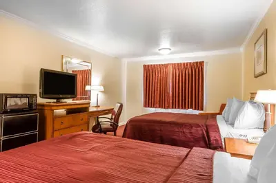 a hotel room with two beds and a flat screen tv at Quality Inn & Suites Gilroy in Gilroy