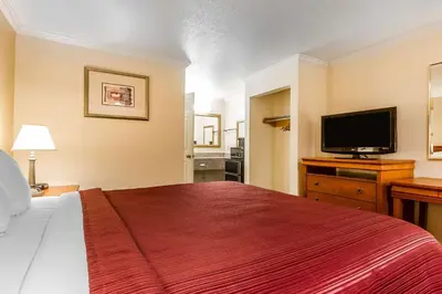 a hotel room with a bed and a flat screen tv at Quality Inn & Suites Gilroy in Gilroy