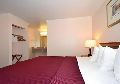 a hotel room with a large bed with a red blanket at Quality Inn & Suites Gilroy in Gilroy