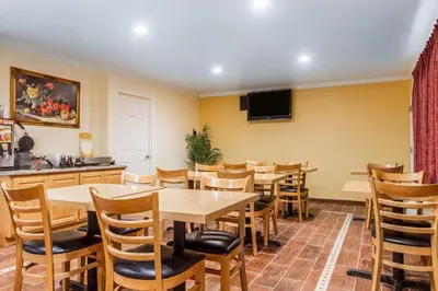 a restaurant with tables and chairs and a tv at Quality Inn & Suites Gilroy in Gilroy