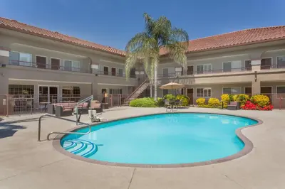 a large swimming pool in front of a building at Baymont by Wyndham Modesto Salida in Modesto