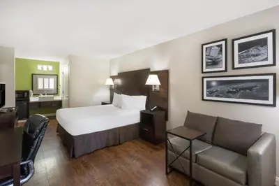 a hotel room with a bed and a couch at Baymont by Wyndham Modesto Salida in Modesto