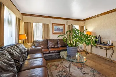 a living room with a leather couch and a glass table at Rodeway Inn at Nevada State Capitol in Carson City