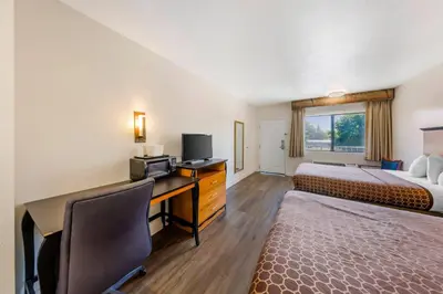 a hotel room with a bed and a desk with a computer at Rodeway Inn at Nevada State Capitol in Carson City