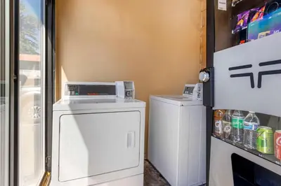 a small kitchen with a washer and dryer next to a refrigerator at Rodeway Inn at Nevada State Capitol in Carson City