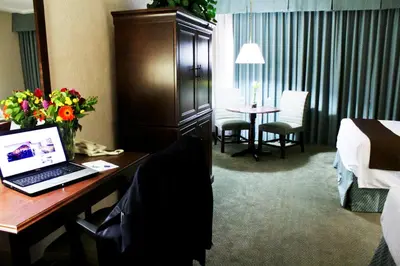a hotel room with a desk with a laptop on it at University Square Hotel in Fresno