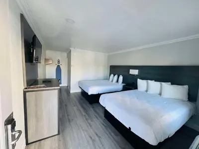 a hotel room with two beds and a television at SureStay by Best Western Fresno Central in Fresno