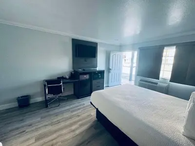 a bedroom with a bed and a desk with a computer at SureStay by Best Western Fresno Central in Fresno