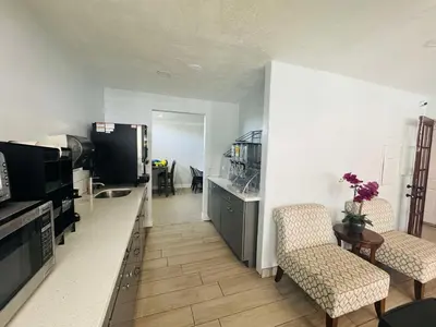 a living room with two chairs and a table and a television at SureStay by Best Western Fresno Central in Fresno