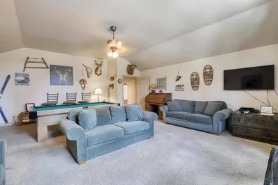 a living room with two blue couches and a pool table at Alderhill in Shaver Lake