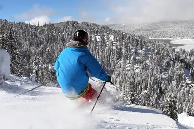 a person is skiing down a snow covered mountain at Alderhill in Shaver Lake