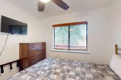 a bedroom with a bed and a dresser and a window at Deaver's Place in Shaver Lake