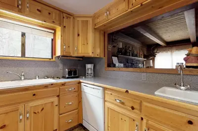 a kitchen with wooden cabinets and a sink at Foxtail Delight in Dora Belle