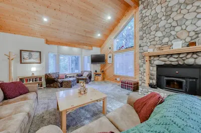 a living room with a stone fireplace and a couch at Hatcher's Hideaway in Shaver Lake