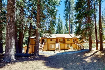 a log cabin in the woods with trees at Huntington Lake Condo 92 in Lakeshore