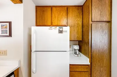 a white refrigerator in a kitchen with wooden cabinets at Huntington Lake Condo 92 in Lakeshore