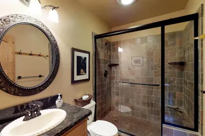 a bathroom with a shower and a sink and a mirror at Loggers Landing in Lakeshore