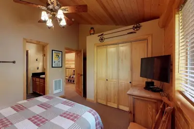 a bedroom with a bed and a flat screen tv at Loggers Landing in Lakeshore