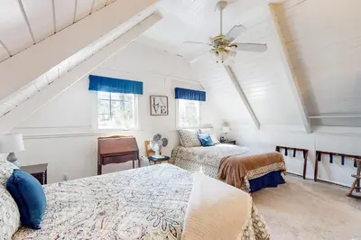 a attic bedroom with two beds and a ceiling at Mountain Memories in Shaver Lake
