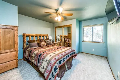 a bedroom with a bed and a ceiling fan at Paw's Cabin in Shaver Lake