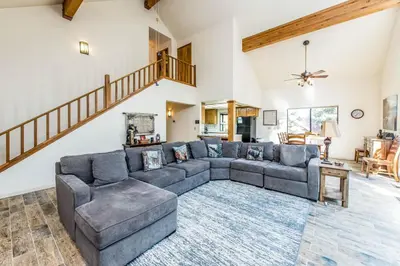 a living room with a couch and a staircase at Paw's Cabin in Shaver Lake