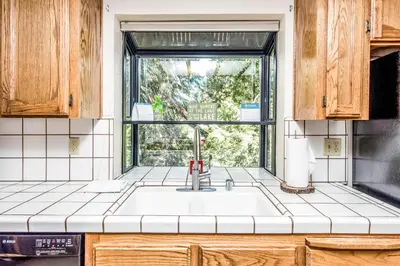 a kitchen with a sink and a window at Paw's Cabin in Shaver Lake
