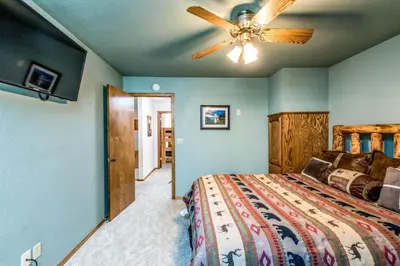 a bedroom with a bed and a ceiling fan at Paw's Cabin in Shaver Lake