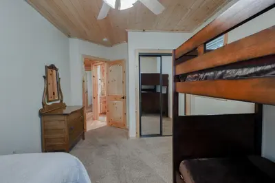 a bedroom with a bunk bed and a wooden ceiling at Pinnacle Point in Shaver Lake