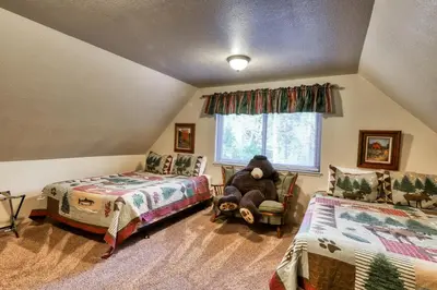 a bedroom with two beds and a chair and a window at The Limit in Dora Belle