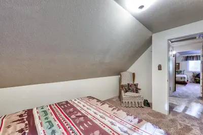 a bedroom with a bed and a chair in a room at The Limit in Dora Belle