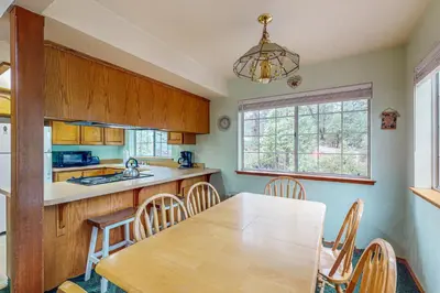 a kitchen with a wooden table and a dining room at Travelers Rest in Shaver Lake Heights