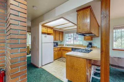 a kitchen with wooden cabinets and a white refrigerator at Travelers Rest in Shaver Lake Heights