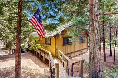 a house with an american flag in front of it at Water's Edge Retreat in Shaver Lake
