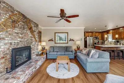 a living room with two couches and a fireplace at Water's Edge Retreat in Shaver Lake