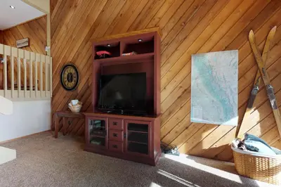 a living room with a television on a wooden wall at Blue Jay Condominium in Lakeshore