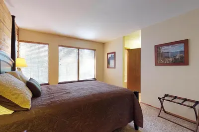 a bedroom with a large bed and two windows at Blue Jay Condominium in Lakeshore