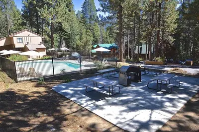 a pool with two picnic tables and a grill at Blue Jay Condominium in Lakeshore
