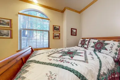 a bedroom with a bed and a window at New England Cottage in Shaver Lake