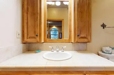 a bathroom with a sink and a mirror at New England Cottage in Shaver Lake
