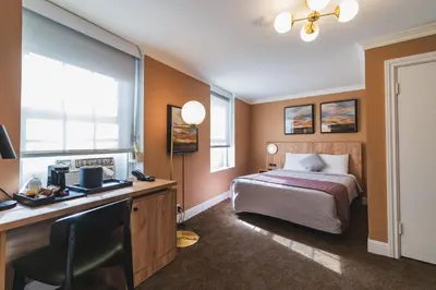 a bedroom with a bed and a desk with a computer at Historic Sonora Inn in Sonora