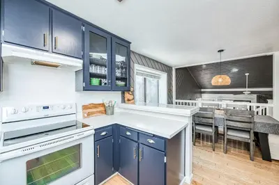 a kitchen with blue cabinets and a dining room at Huntington Lake Condo 115 in Lakeshore