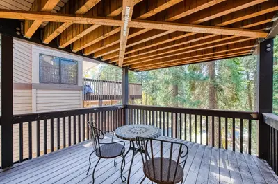 a patio with a table and chairs on a deck at Huntington Lake Condo 115 in Lakeshore