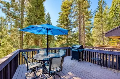 a table and chairs on a deck with an umbrella at Huntington Lake Condo 115 in Lakeshore