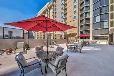 a patio with tables and chairs and a red umbrella at Plaza Resort Club Reno in Reno