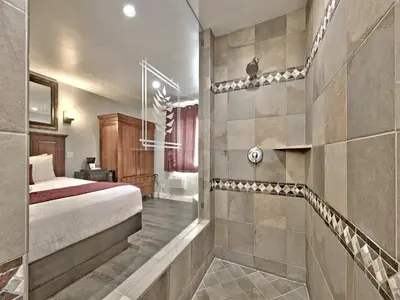 a bedroom with a bed and a walk in shower at Secrets Inn Lake Tahoe in South Lake Tahoe