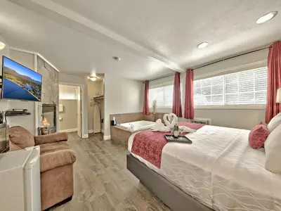 a bedroom with a large bed and a tub at Secrets Inn Lake Tahoe in South Lake Tahoe